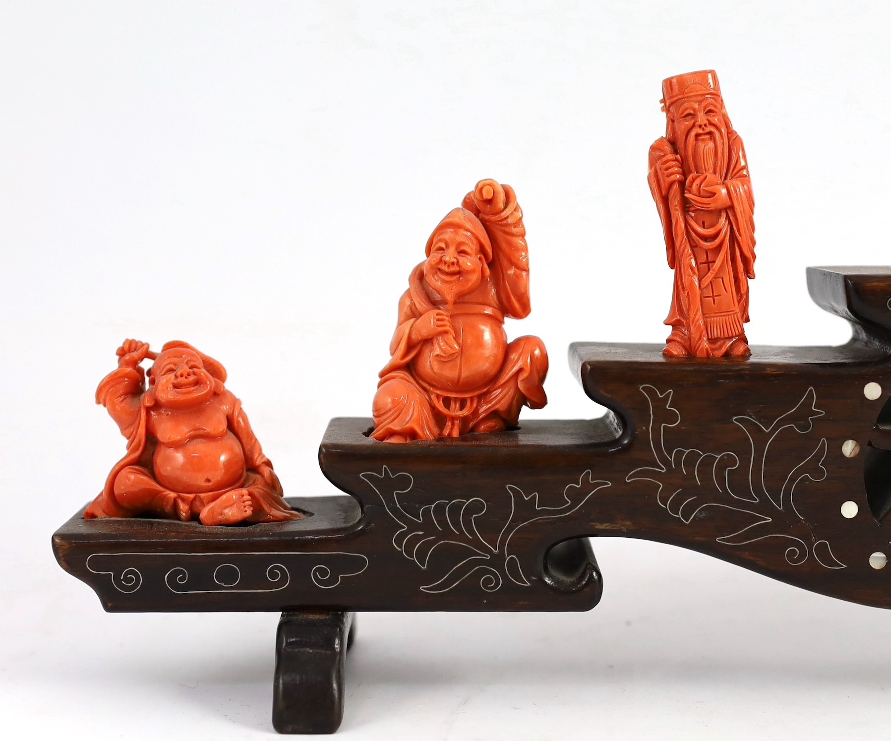 A Chinese or Japanese set of seven coral figures of immortals, 43cm wide, figures 4 to 8cm high